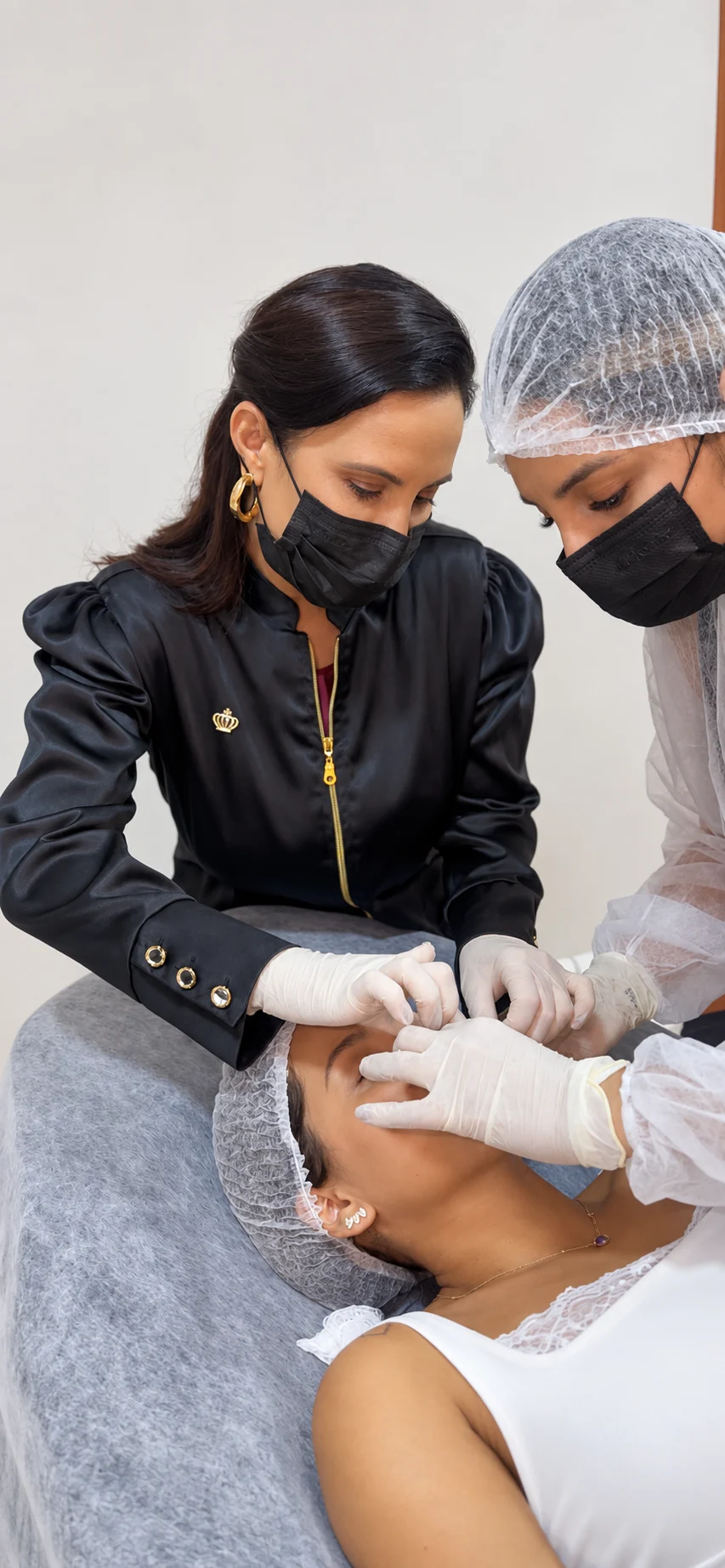 Ilma Freitas acompanha uma aluna durante atividade prática facial.